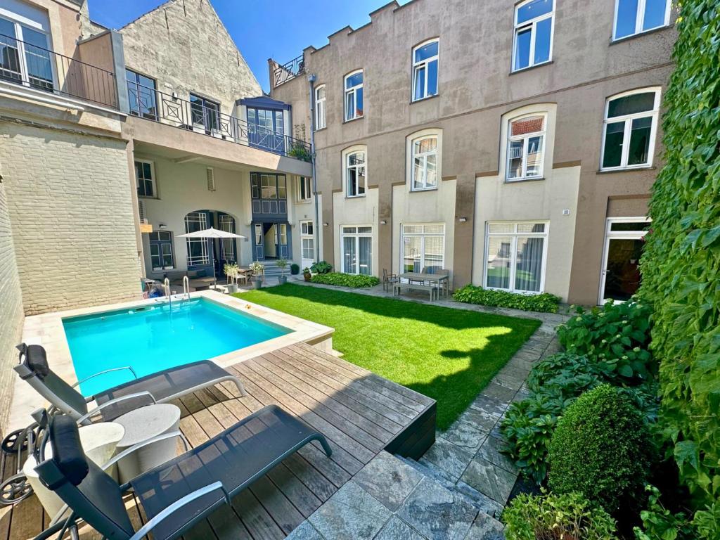 un cortile con piscina di fronte a un edificio di De Drie Koningen a Bruges