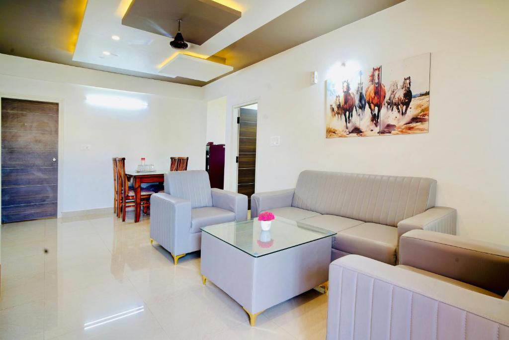 un soggiorno con divano e tavolo di Elite Enclave - Mysore - 2BHK Luxury Serviced Apartments a Mysore