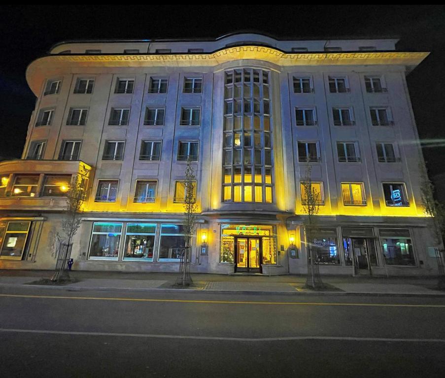 un bâtiment éclairé dans une rue de la ville la nuit dans l'établissement Hotel Athmos, à La Chaux-de-Fonds