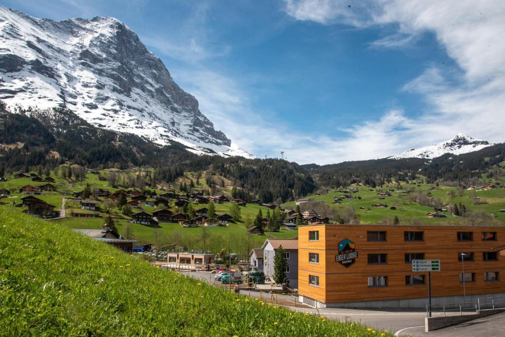 een gebouw op een heuvel met bergen op de achtergrond bij Eiger Lodge Chic in Grindelwald