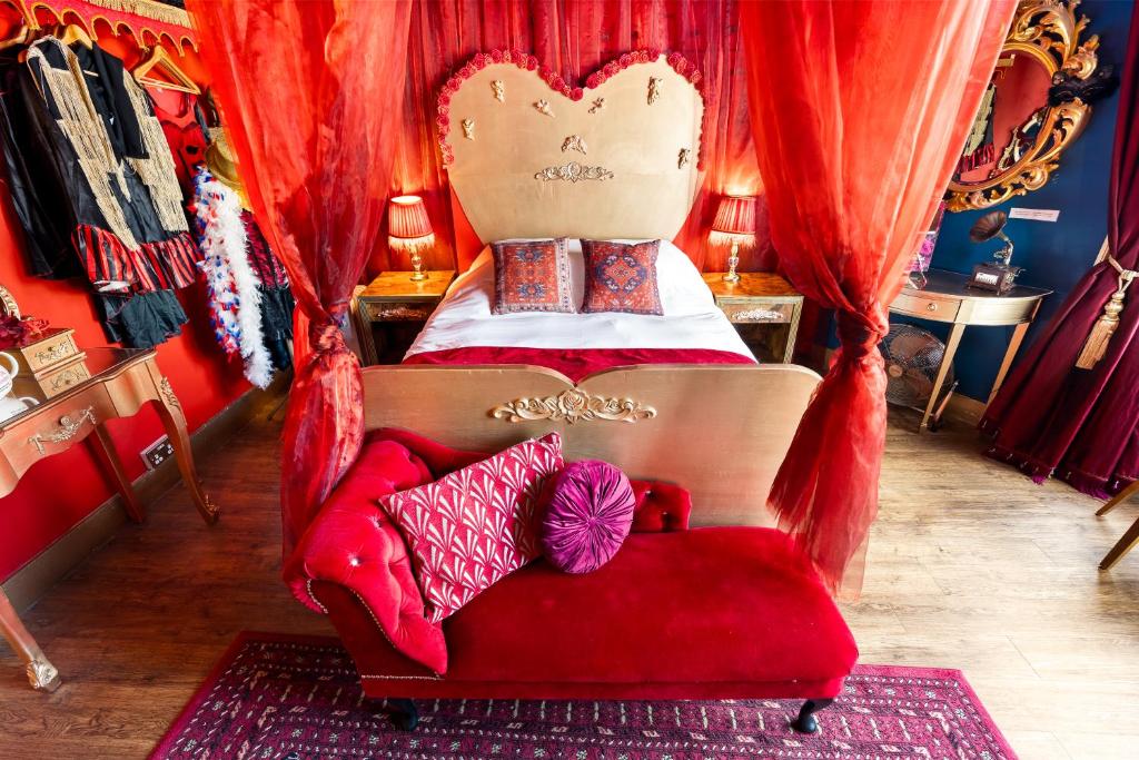 een slaapkamer met een rood bed en een rode bank bij Hotel Pelirocco in Brighton & Hove