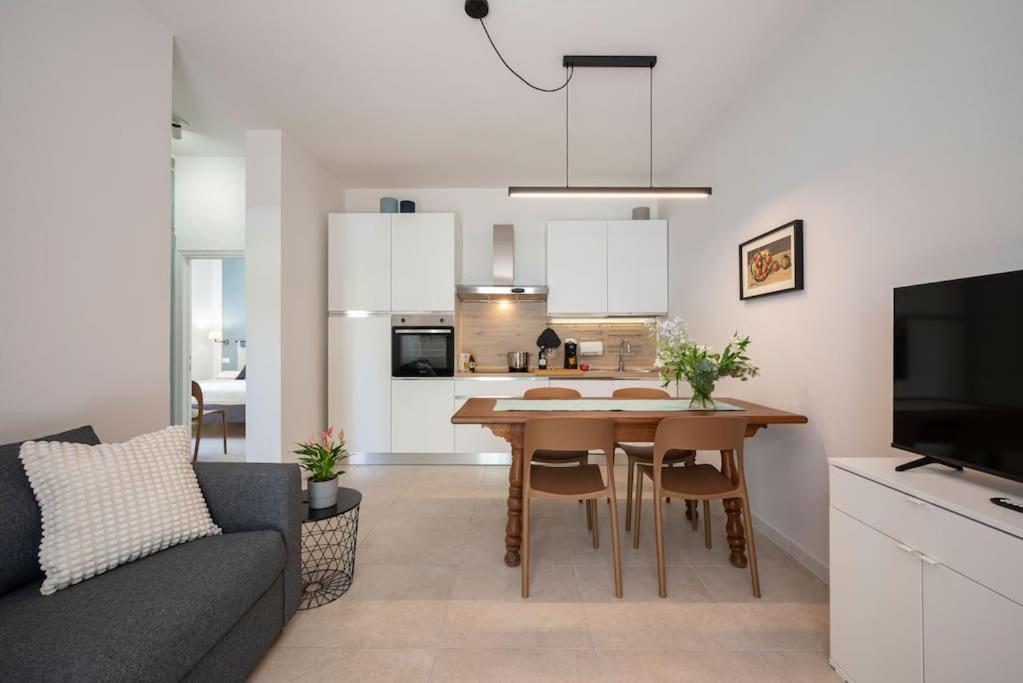 uma sala de estar e cozinha com uma mesa e um sofá em Follonica Seahouse Vivi la Magia del Mare em Follonica