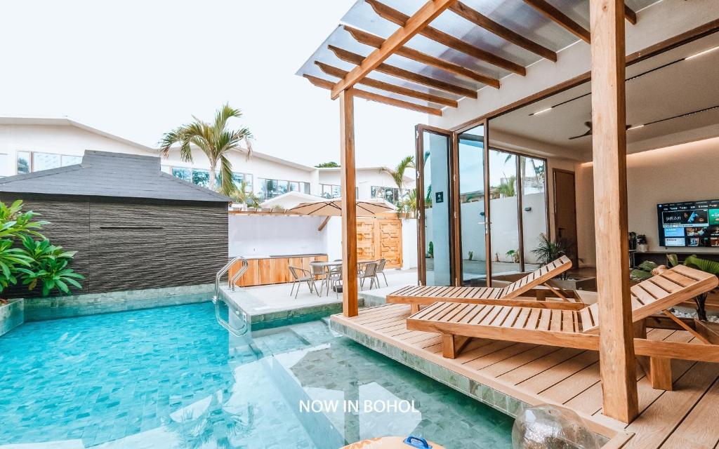 uma casa com piscina e um deque com bancos em Chez Judy Resort em Panglao City