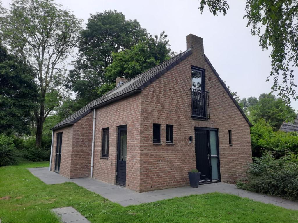 EwijkVakantiewoning Maas en Waal 100的一座旧砖砌的建筑,上面有时钟