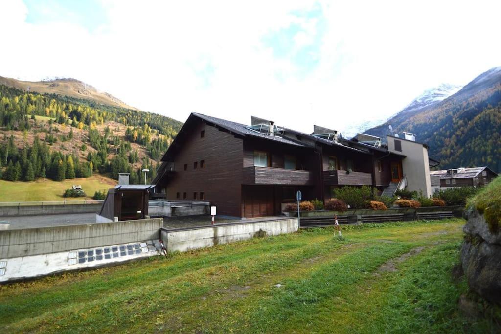 un grande edificio in un campo vicino a una montagna di Ary Holiday Home Ski , Bike & Walk a Santa Caterina Valfurva