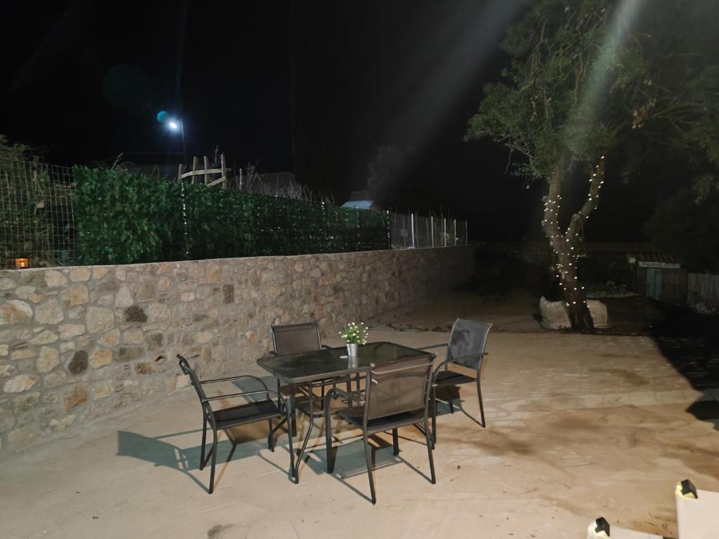 a table with chairs and a laptop on it at Vaki's country house in Pylos