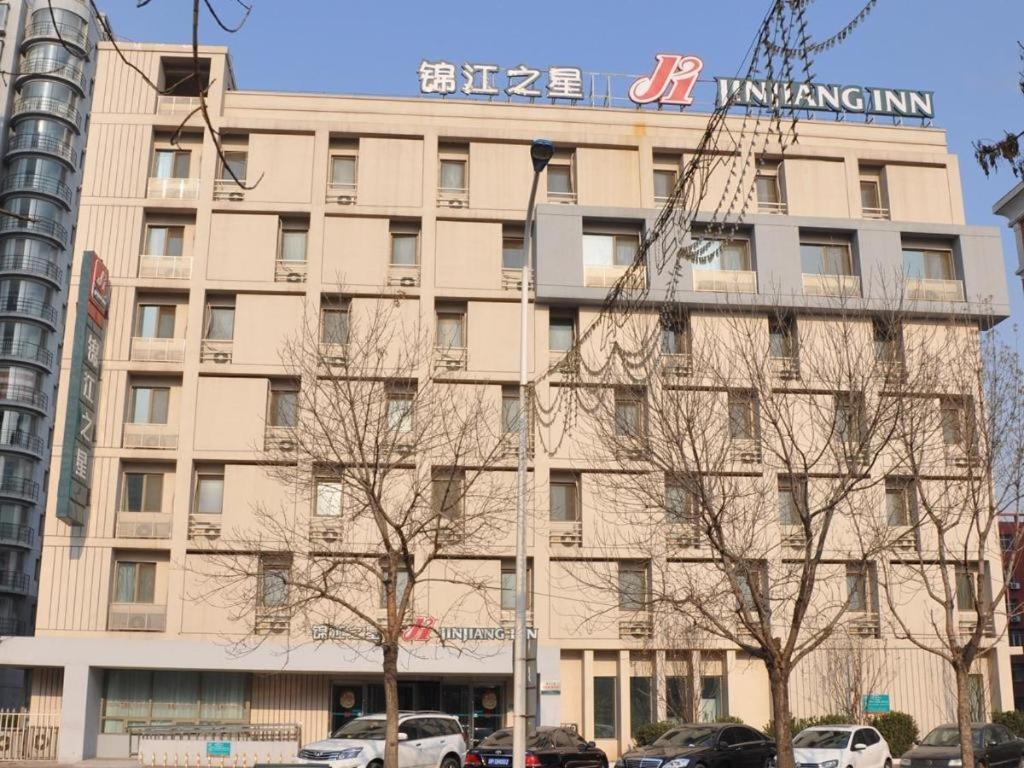 Jinjiang Inn Tianjin Development Zone Branch في Binhai: مبنى كبير عليه لافته