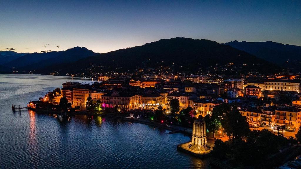 une ville à côté de l'eau la nuit dans l'établissement Casa Gambusso historical house magnificent Lake View, à Verbania