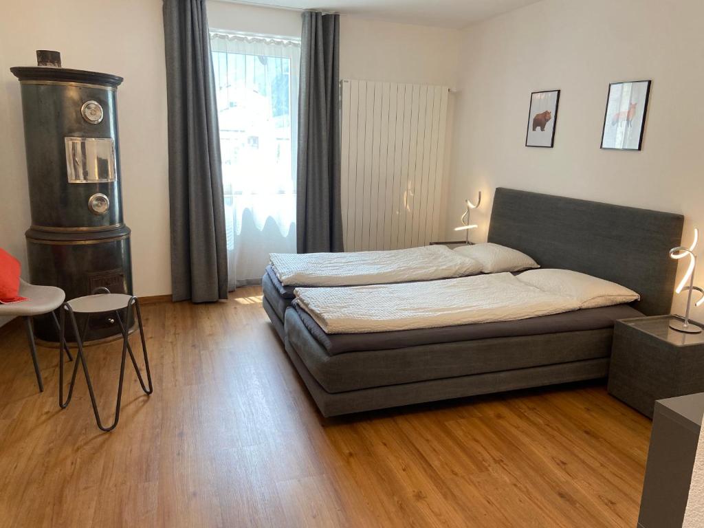 1 dormitorio con cama, mesa y ventana en B&B Berninapass, en Poschiavo