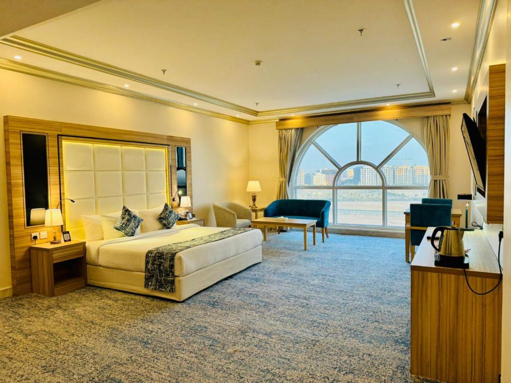 een hotelkamer met een bed en een groot raam bij Casa Diora Hotel Jeddah in Jeddah