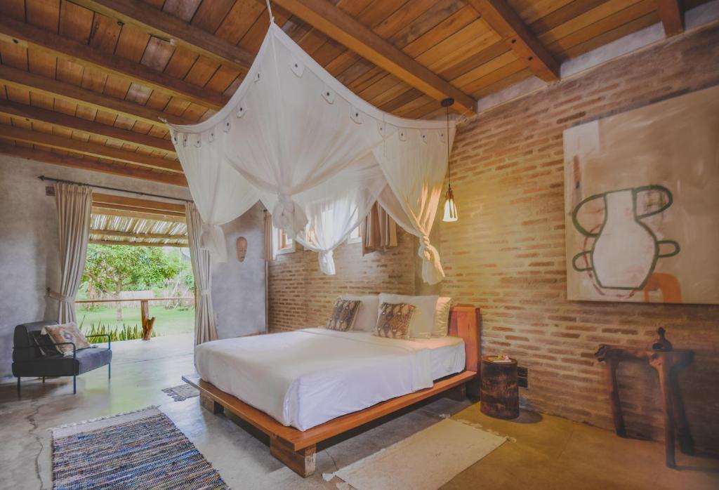 een slaapkamer met een bed met een klamboe bij Iron Rose Villa with garden & pool Kuta Lombok in Kuta Lombok