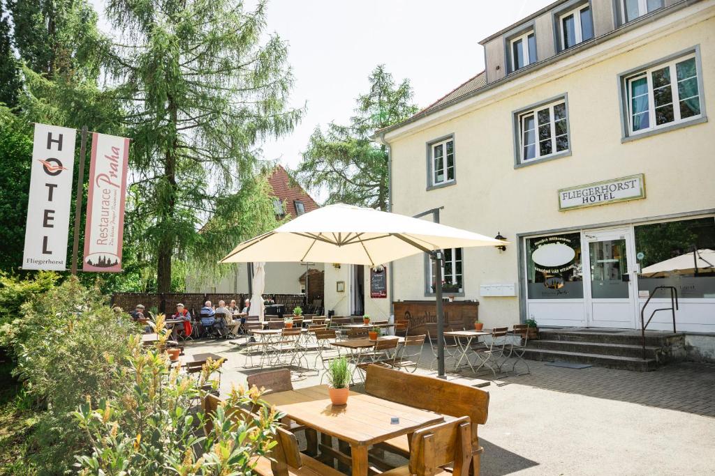 een restaurant met tafels en parasols voor een gebouw bij Fliegerhorst in Dresden