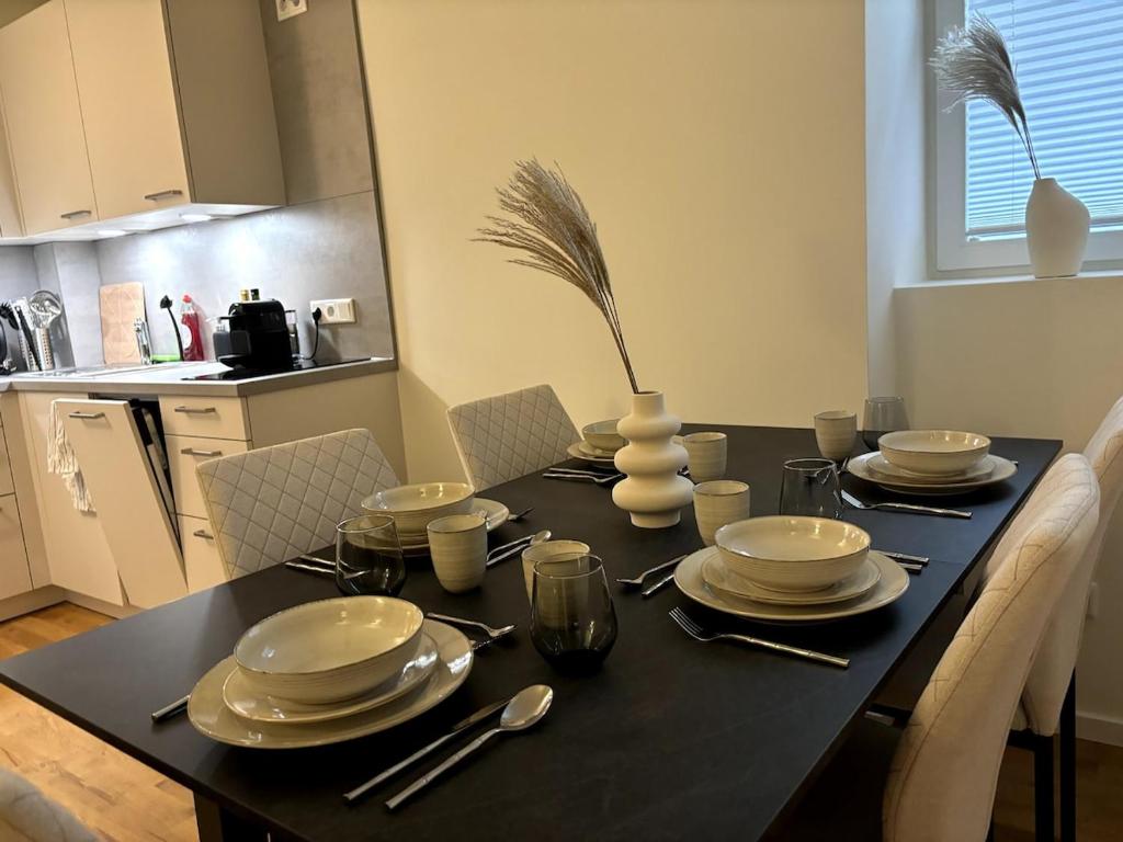 uma mesa de jantar com pratos e utensílios em City Apartment am Fluss em Frankfurt am Main