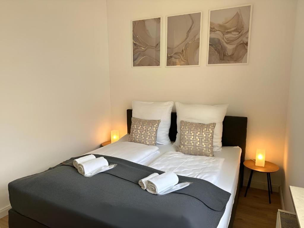 Dos camas en un dormitorio con dos velas. en RAHA Apartments - Modernes Studio-Apartment - am HBF - kostenloser Parkplatz, en Erfurt