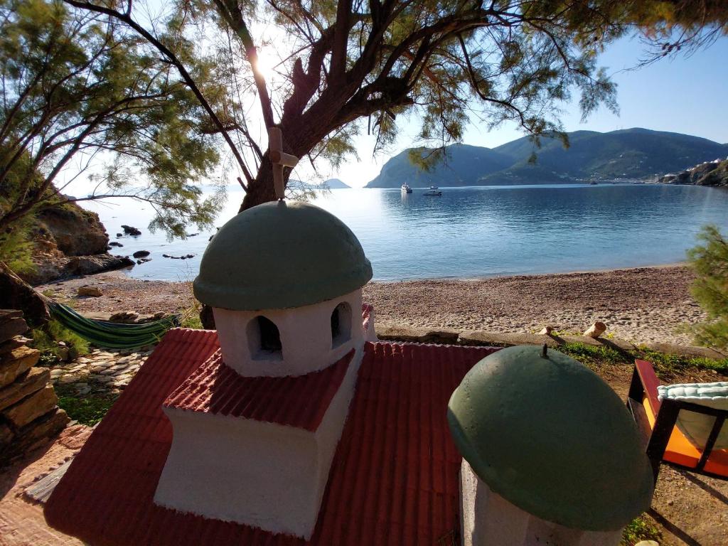 un piccolo edificio con una cupola verde su una spiaggia di Maeiz Skopelos a Skopelos Town