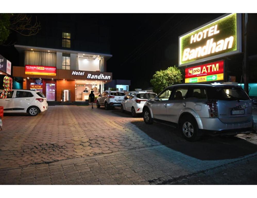 un gruppo di auto parcheggiate in un parcheggio di notte di Hotel Bandhan, Shirdi a Shirdi