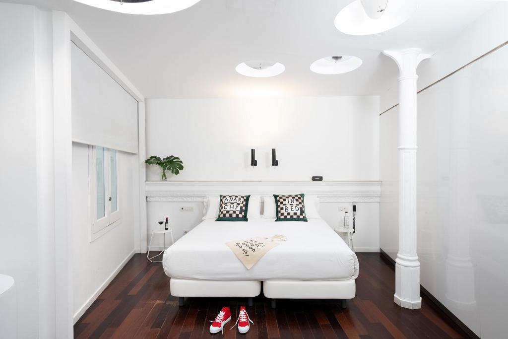 - une chambre avec un lit blanc et des chaussures rouges au sol dans l'établissement Chic & Basic Born Boutique Hotel, à Barcelone