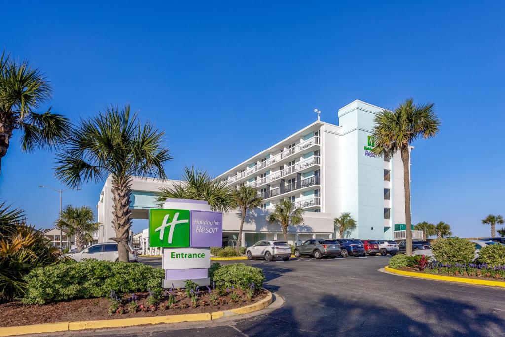 una señal frente a un edificio con palmeras en Holiday Inn Resort Oceanfront at Surfside Beach, an IHG Hotel, en Myrtle Beach