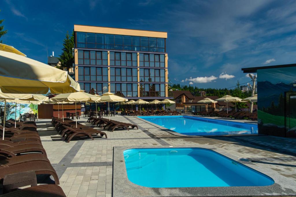 un hotel con piscina y sillas y un edificio en Summit, en Yablunytsya