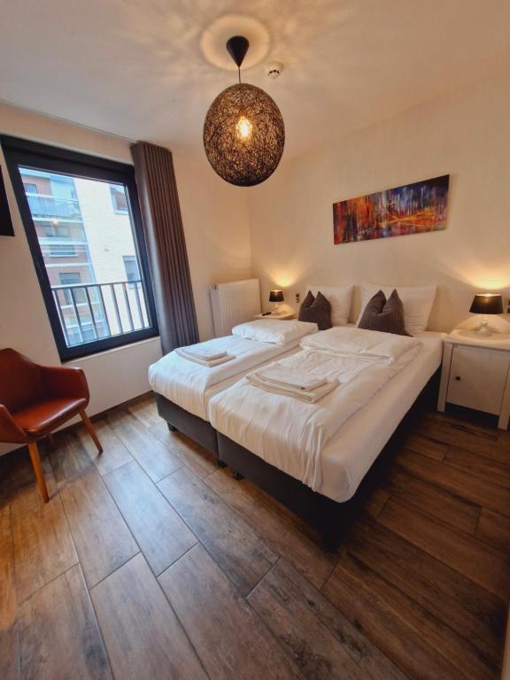 a bedroom with a large bed and a large window at Hotel Ladeuze in Leuven