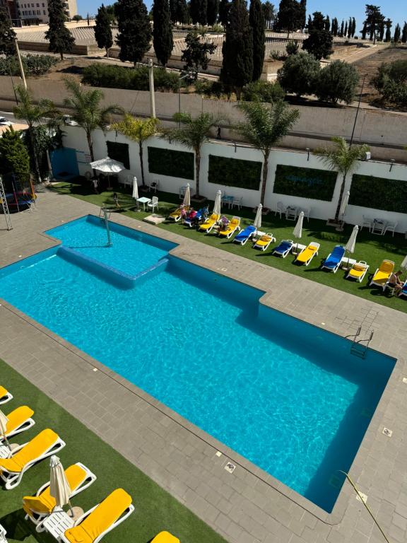 vista sulla piscina con sedie a sdraio di Le Zenith Hotel Oran a Orano