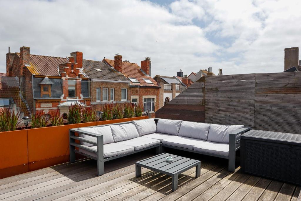 eine Couch und ein Tisch auf dem Dach in der Unterkunft Maison d'O in Ostende