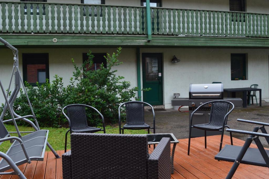 a group of chairs sitting on a deck with a grill at Guesthouse & sauna by HMTL in Liepāja