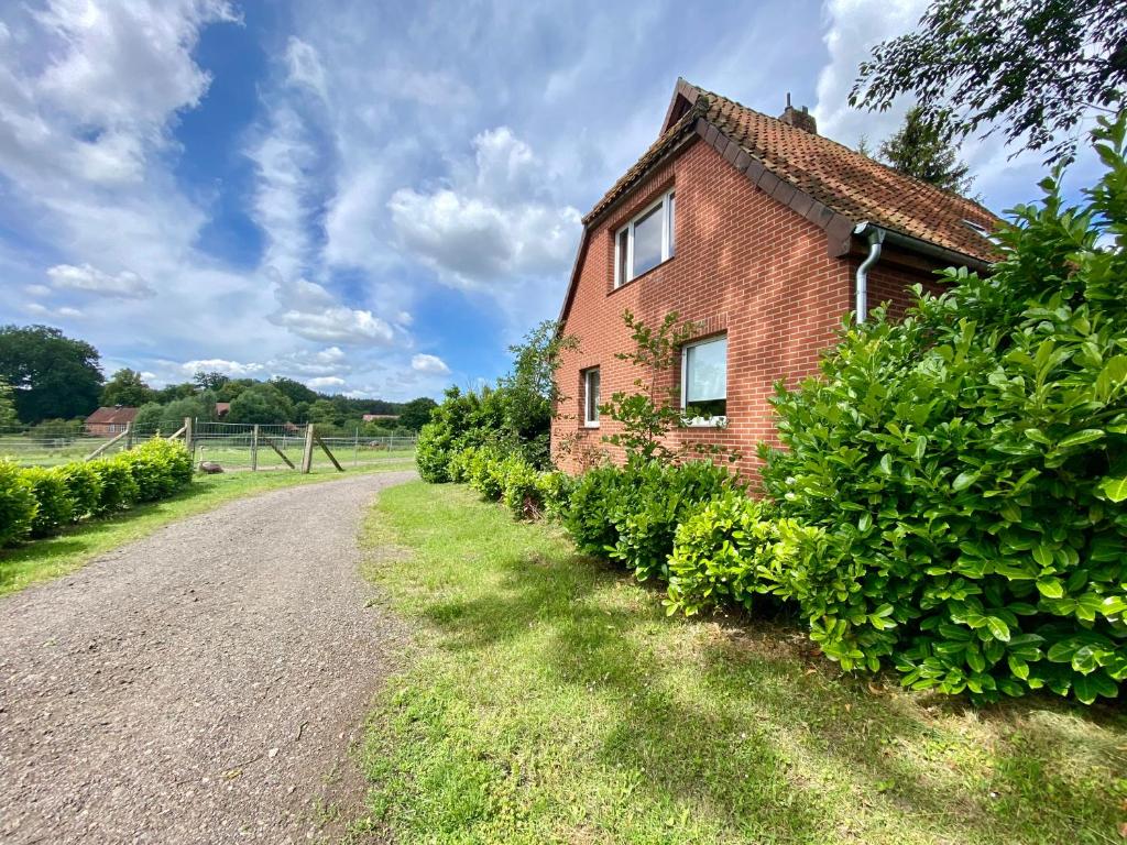 an old brick house on a gravel road at Ferienhaus Straußenblick in Bad Fallingbostel