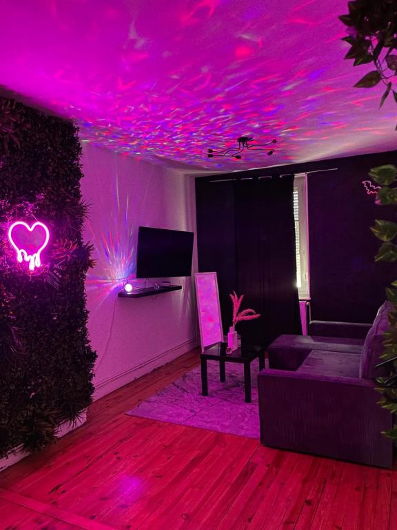 - un salon avec un éclairage rose et un canapé dans l'établissement Appartement cosy LYON, à Villeurbanne