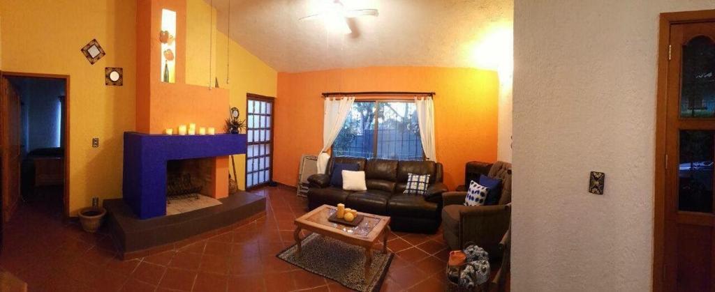 サン・ファン・コサラにあるcasita mirador san juan cosalaのリビングルーム(ソファ、暖炉付)