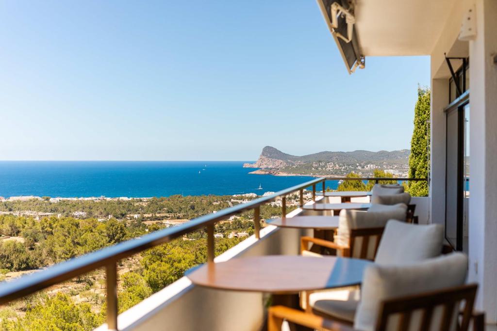 a balcony with tables and chairs and a view of the ocean at Victoria Sunset Suites in San Antonio