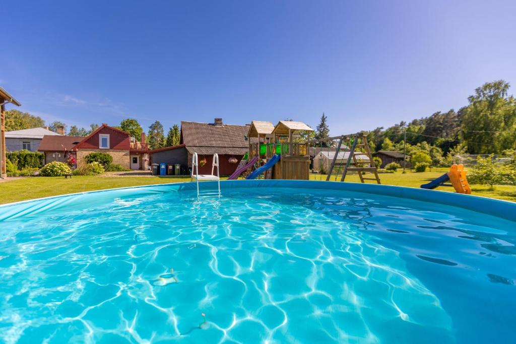 une grande piscine avec une aire de jeux en arrière-plan dans l'établissement Schneider hause, à Jurmala