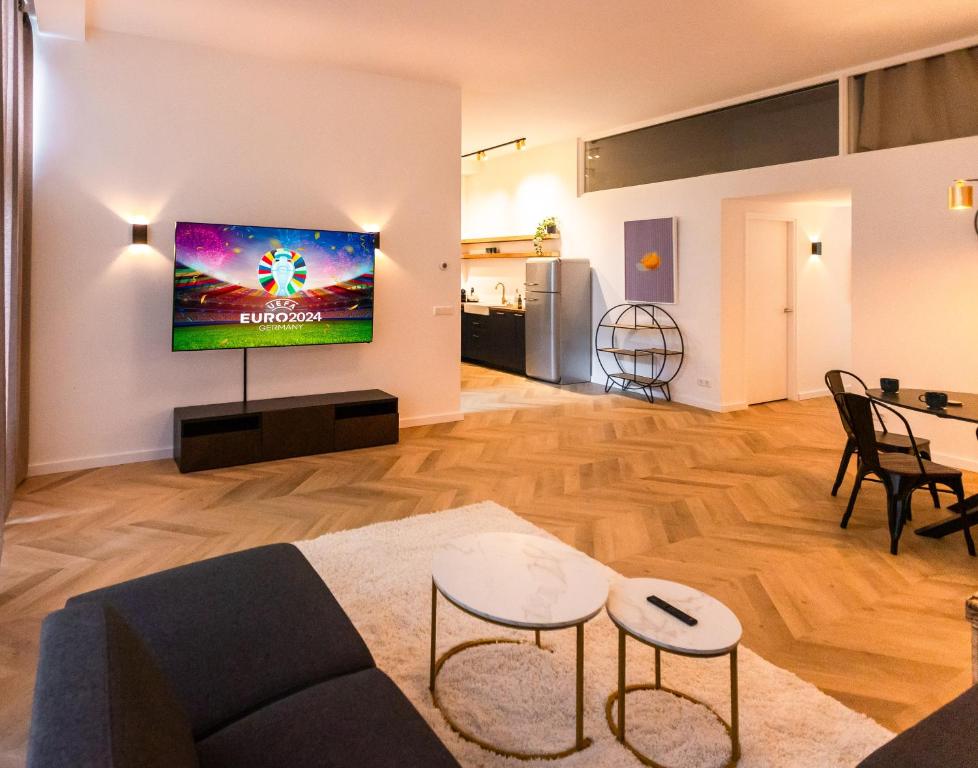 - un salon avec un canapé et une télévision murale dans l'établissement 6 persons Luxury Appartement in Citycentre Breda, à Breda