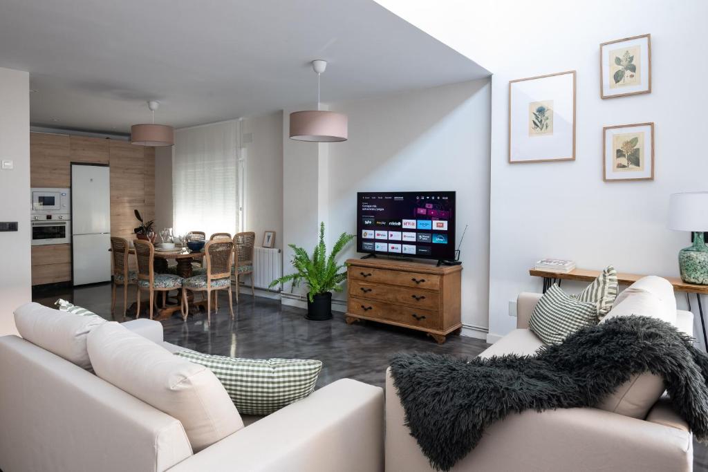 ein Wohnzimmer mit einem weißen Sofa und einem TV in der Unterkunft Casa Jado Loft en Santander in Santander