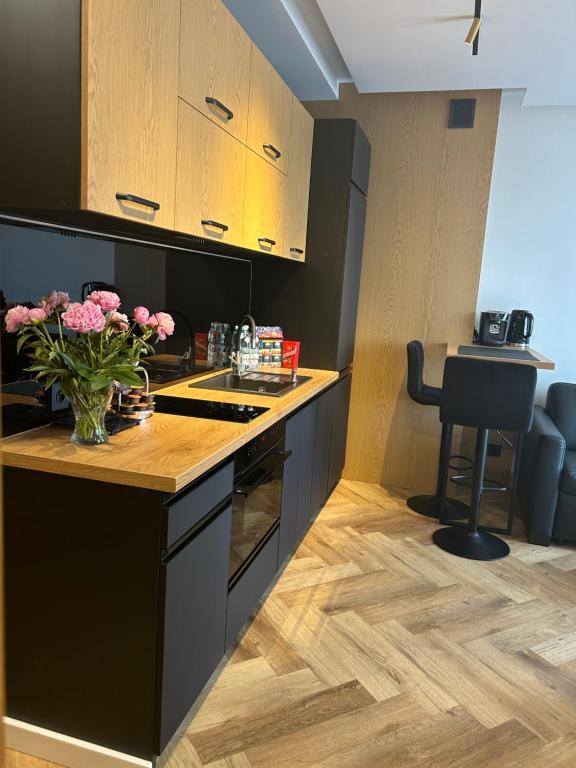 eine Küche mit einer Theke mit einer Vase aus Blumen in der Unterkunft Business Apartment Płock in Płock