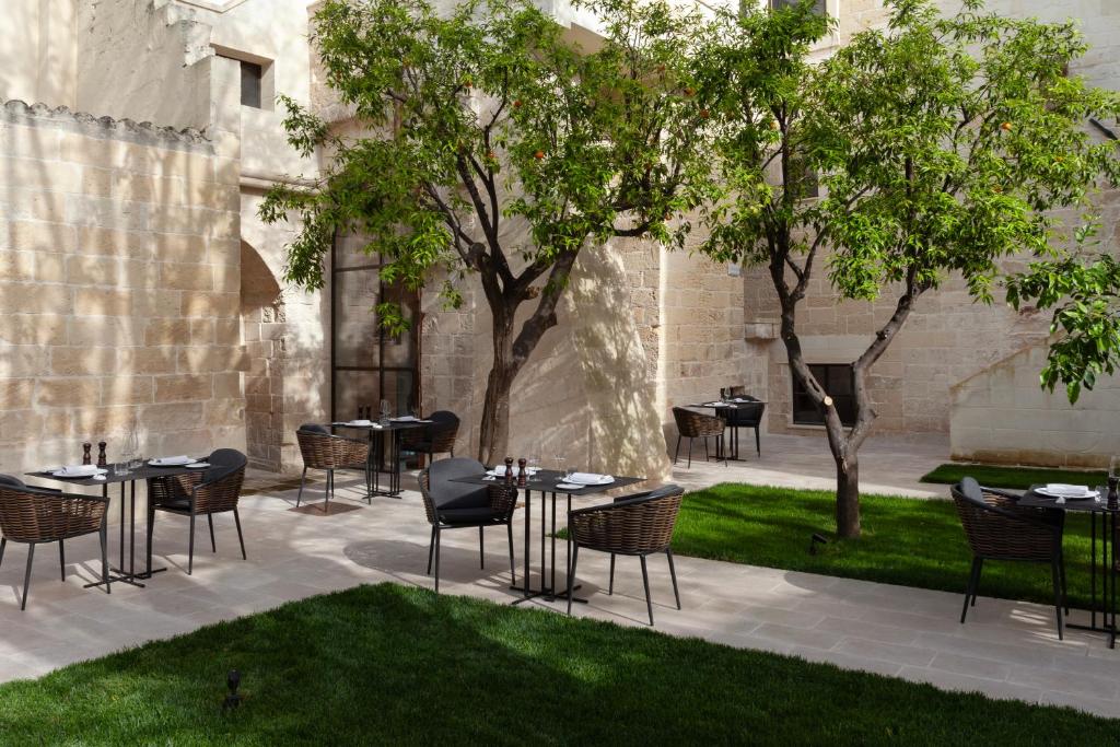 um pátio com mesas e cadeiras num pátio em Palazzo Zimara Boutique Hotel em Lecce