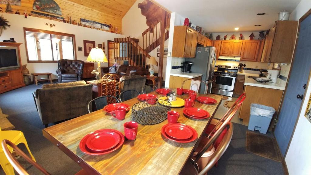 una mesa con platos rojos en la cocina en Birds and Bears Retreat - On The River - Pet Friendly - WiFi - Satellite - Washer - Dryer - Large Deck - Grill - Fenced In Yard, en Red River