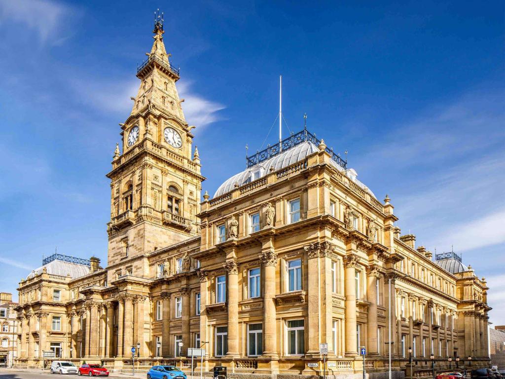 um edifício com uma torre de relógio em frente em The Municipal Hotel Liverpool - MGallery em Liverpool