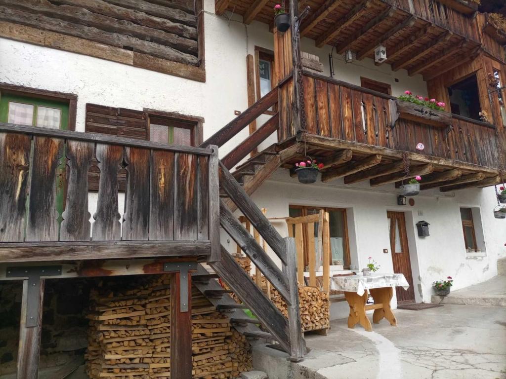 uma casa com uma escada de madeira e uma varanda em Il cuore delle dolomiti em Vinigo