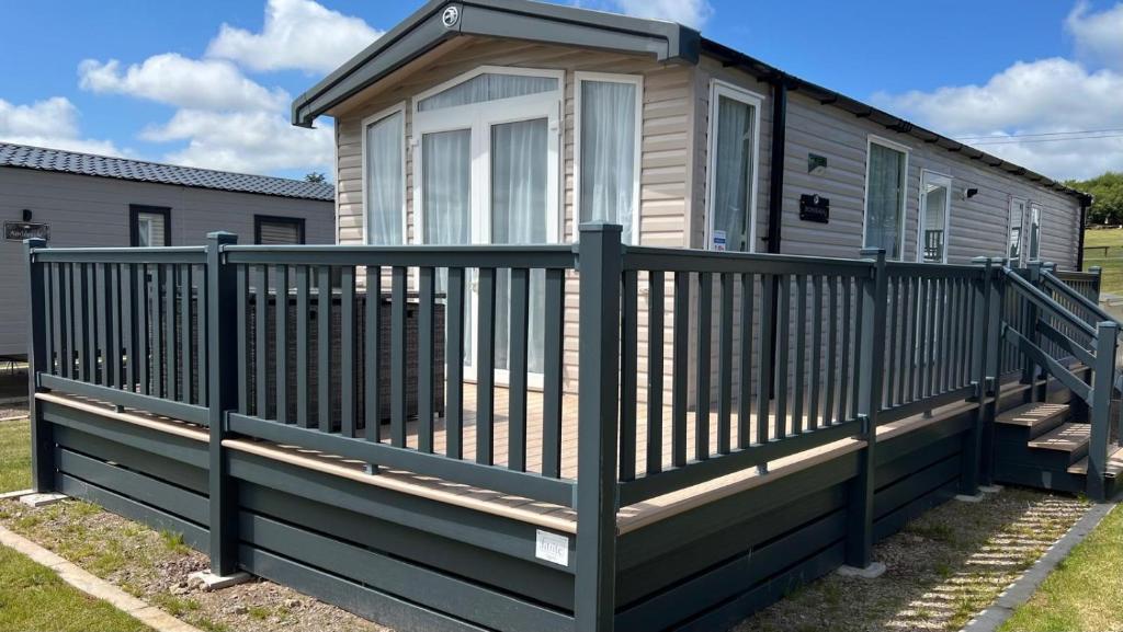 une maison avec une balustrade en bois sur une terrasse dans l'établissement 014b Medina Rise Thorness Bay, à Porchfield