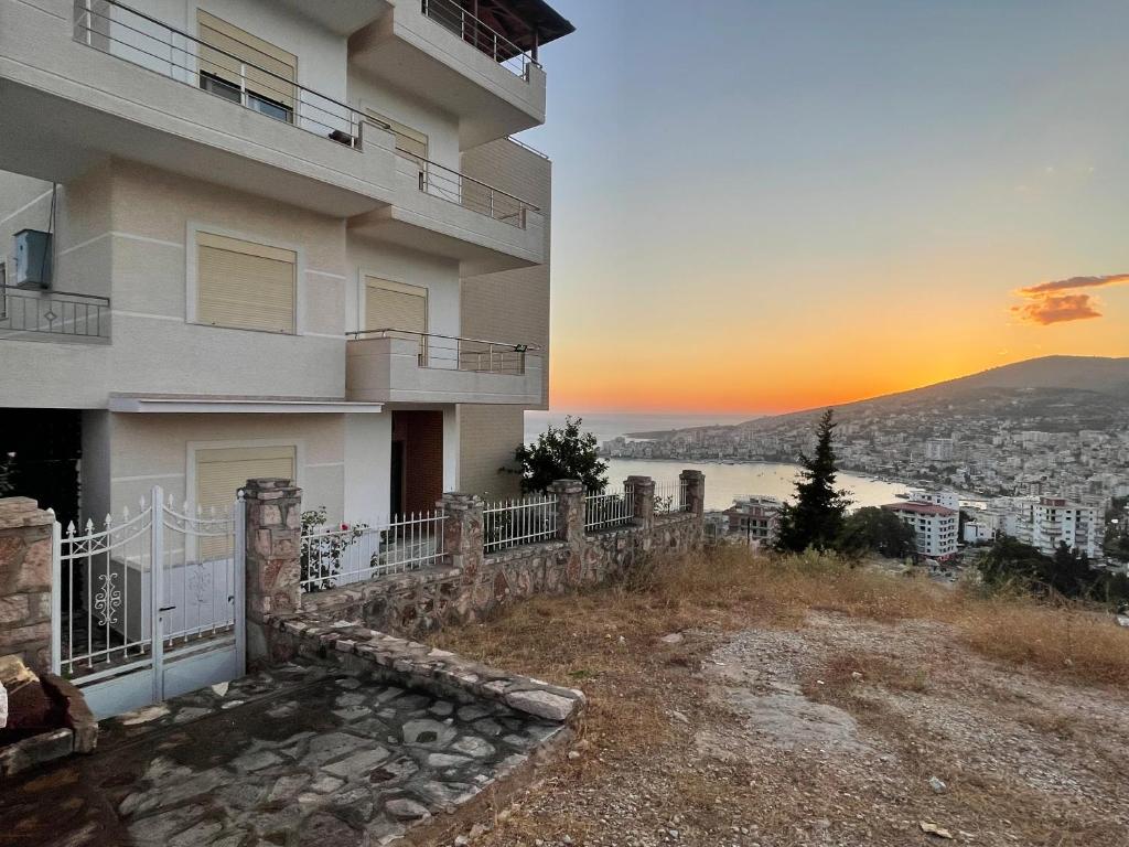 un edificio de apartamentos con la puesta de sol en el fondo en Elision Apartments, en Sarandë