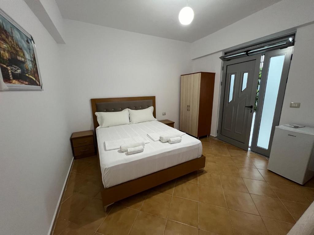 1 dormitorio con 1 cama grande con sábanas blancas en Anna Rooms, en Sarandë