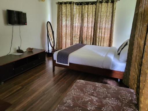 - une chambre avec un lit et une télévision dans l'établissement Three Hills Resort Coorg, à Madikeri