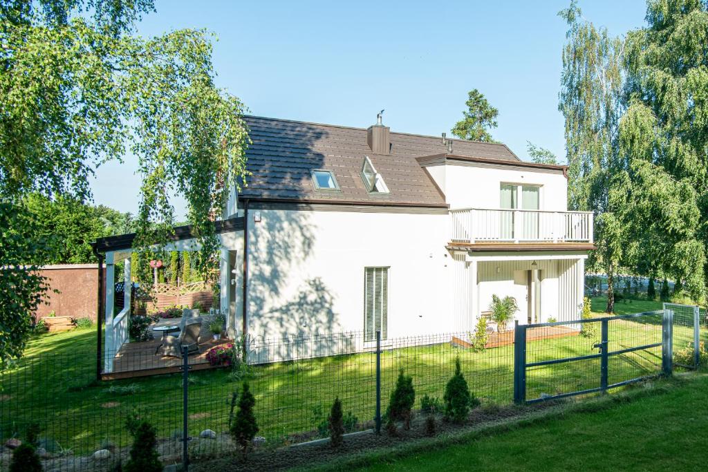 ein weißes Haus mit einem Zaun im Hof in der Unterkunft Leo House in Gdynia