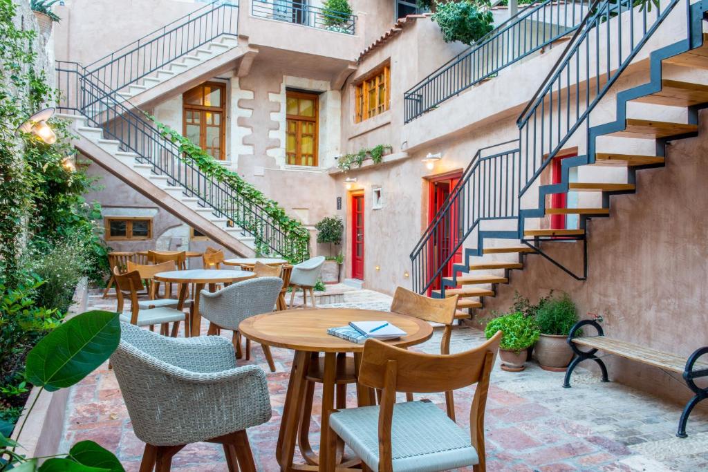 een patio met tafels, stoelen en trappen bij Hotel Off in Chania