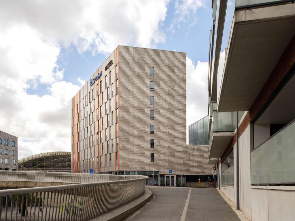 un grand bâtiment avec une passerelle devant lui dans l'établissement ibis budget Leuven Centrum, à Louvain