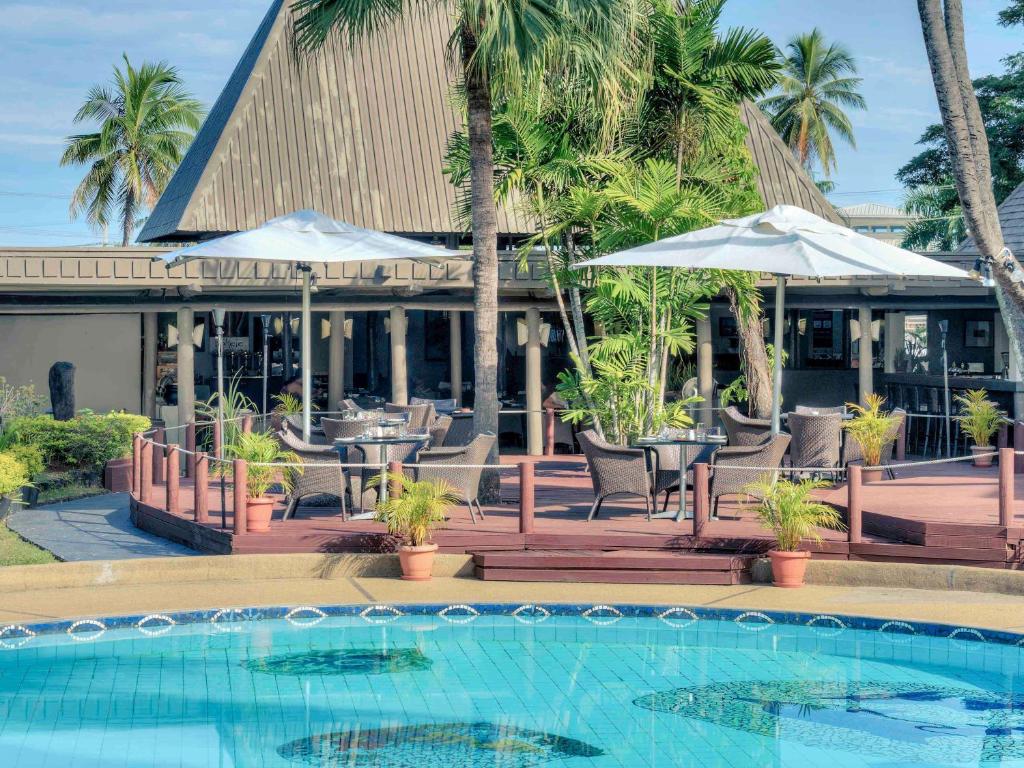 ein Resort mit einem Pool mit Stühlen und Sonnenschirmen in der Unterkunft Mercure Nadi in Nadi