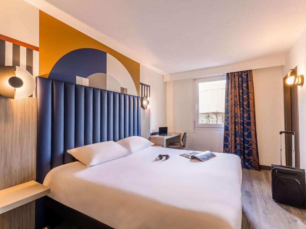 מיטה או מיטות בחדר ב-ibis Styles Saint-Quentin