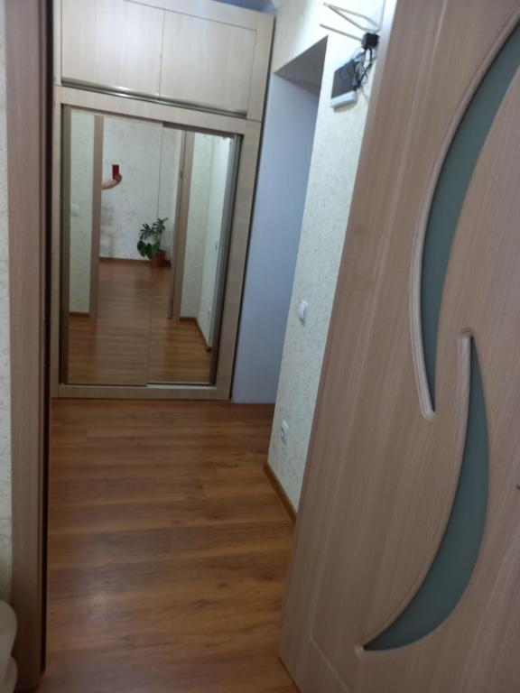 a hallway with a door and a person in the mirror at Elos-Home in Tbilisi City