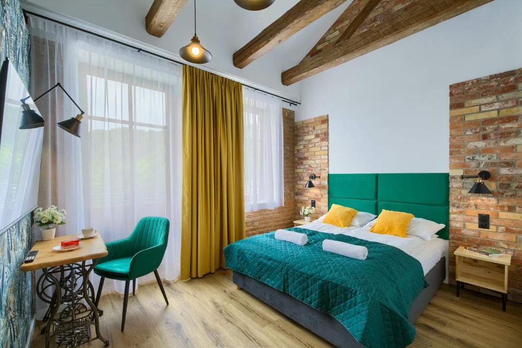 una camera con letto verde, tavolo e sedia di Apartamenty Pod Bocianem a Muszyna